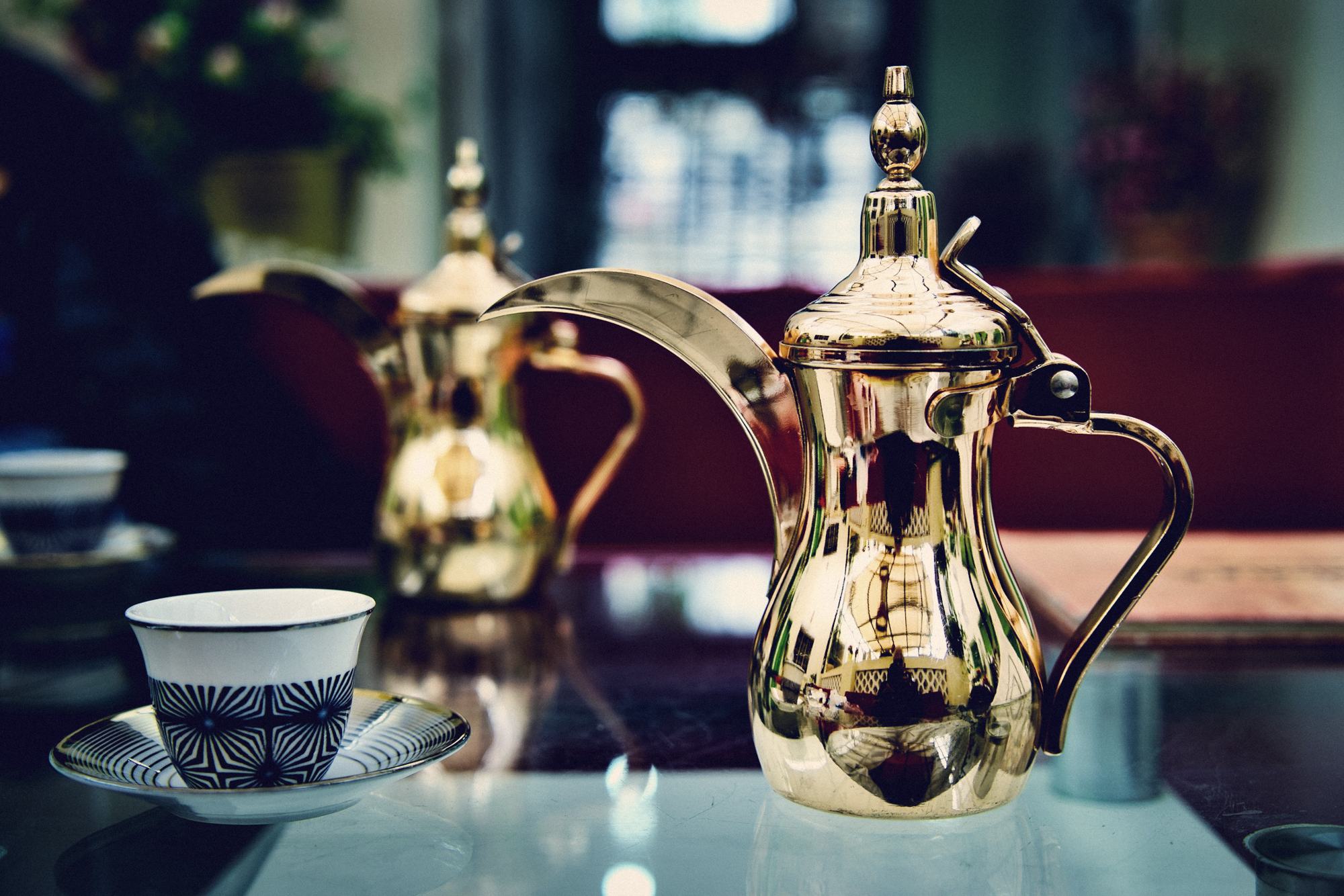 A brass dallah and coffee cups