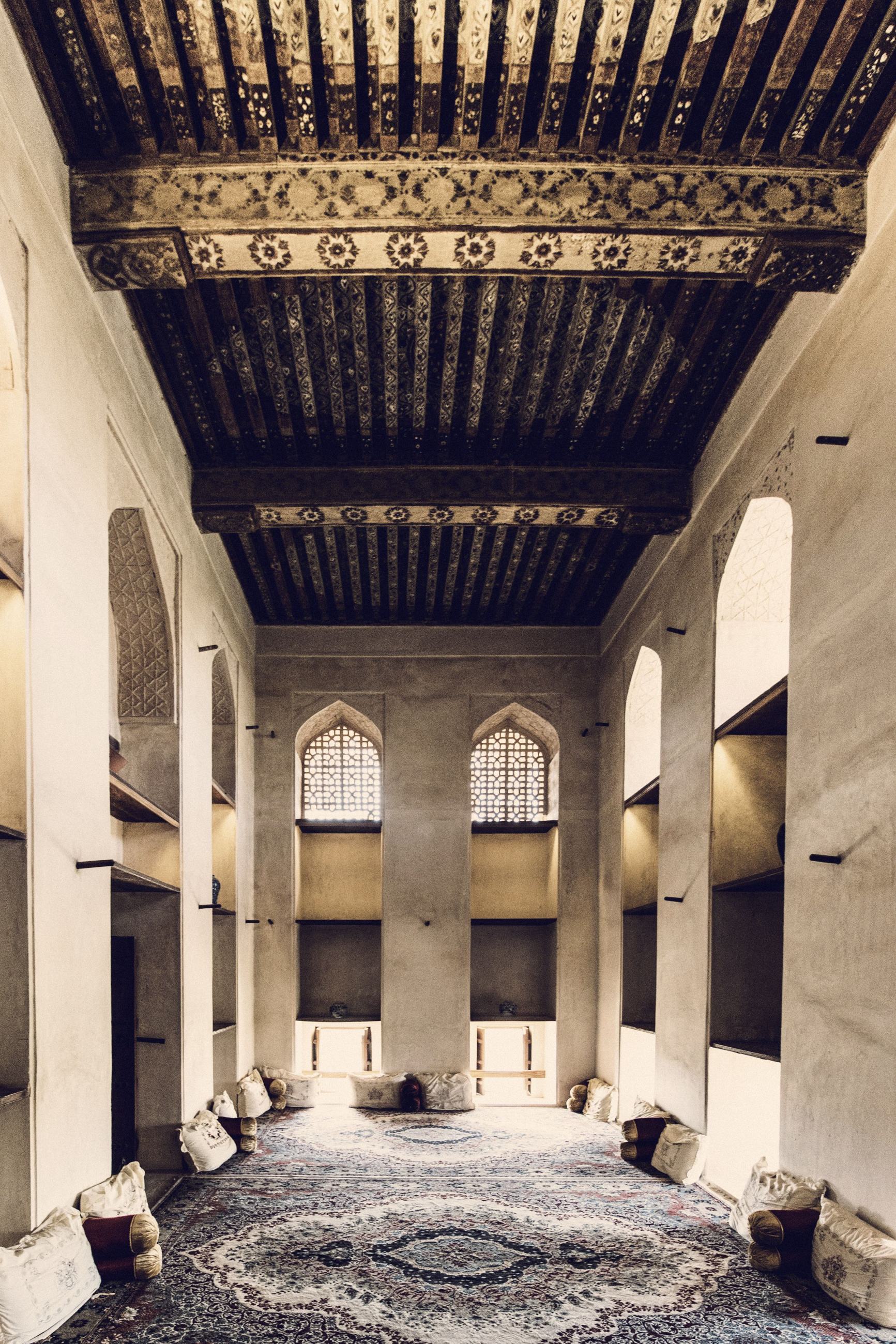 A traditional Gulf interior with arched windows and a timber ceiling