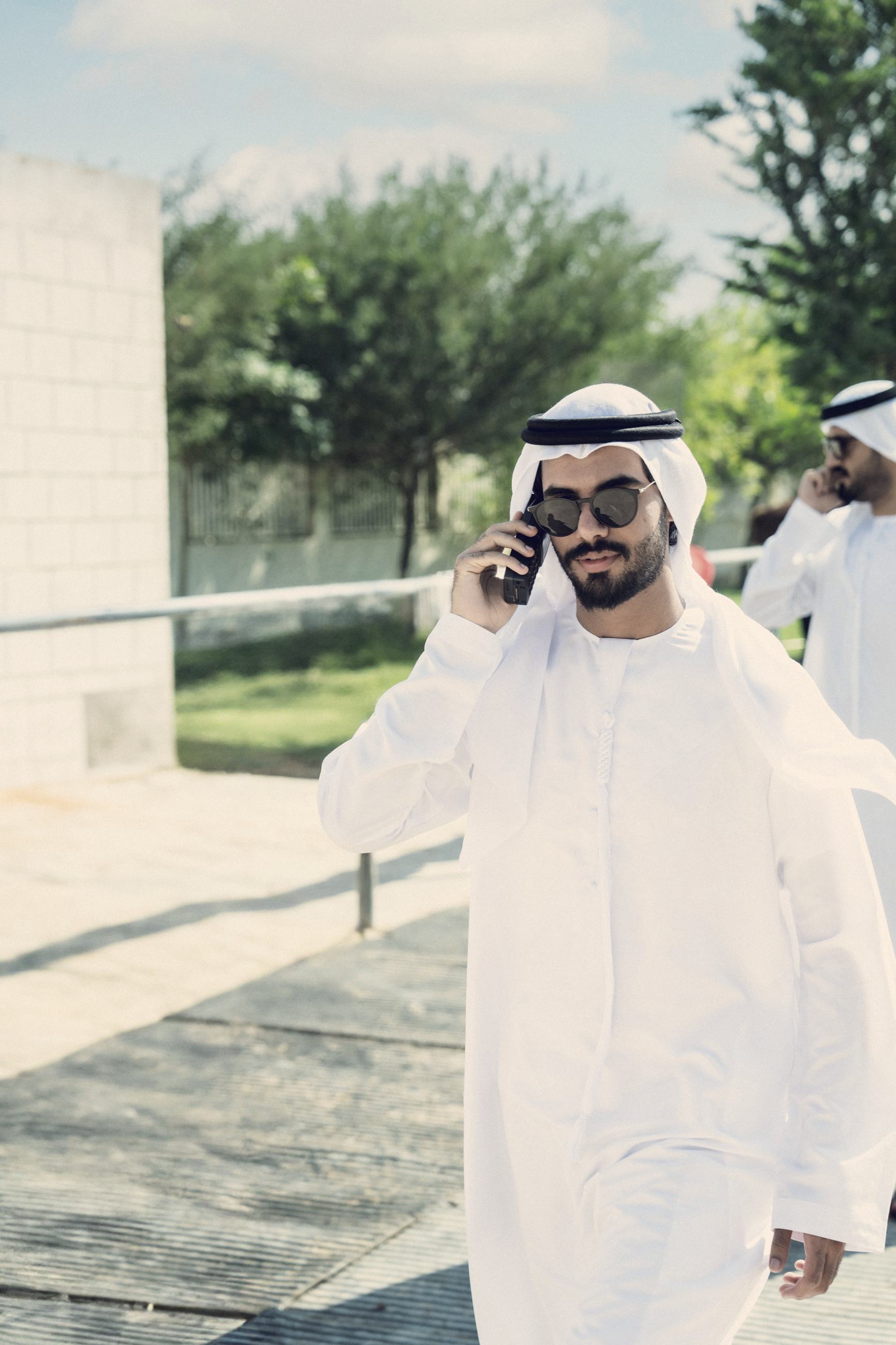 A man in a white ghutra on his phone in Doha