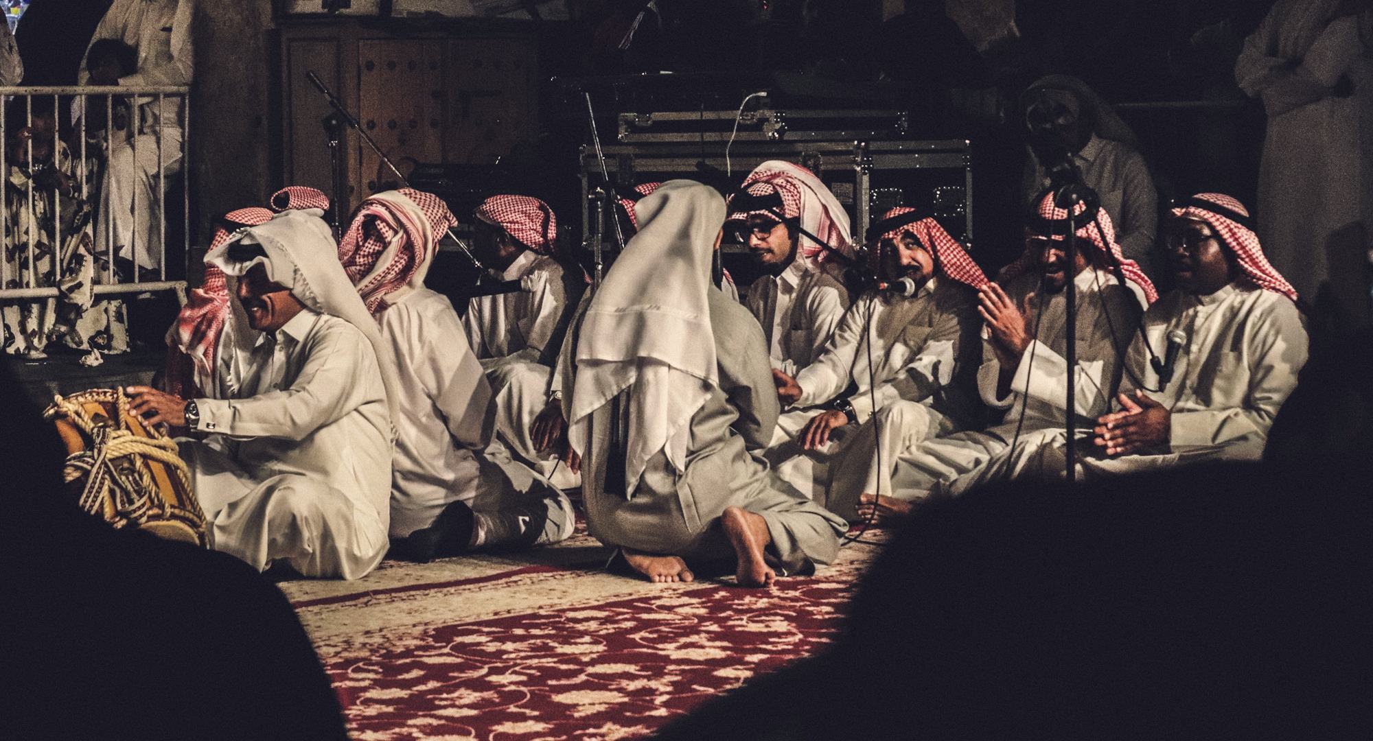 Men in ghutras gathered in conversation in a majlis
