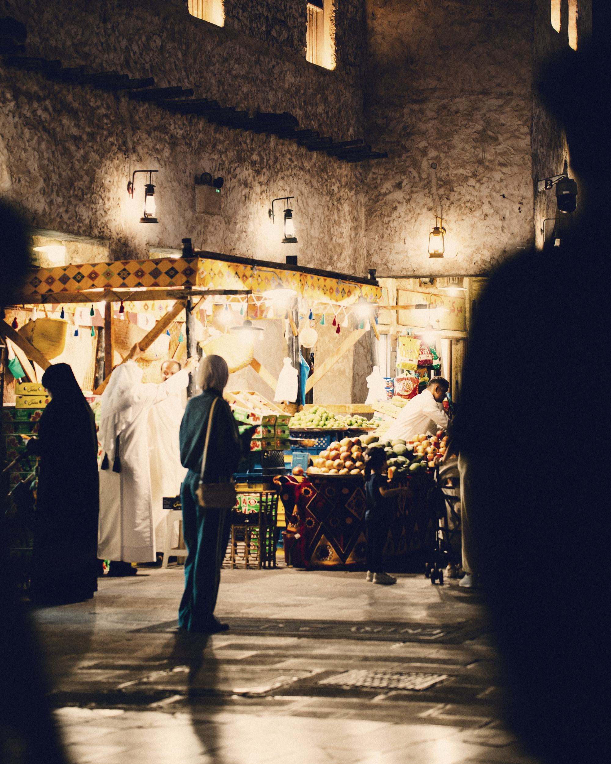 Shoppers at a lit stall in Souq Waqif
